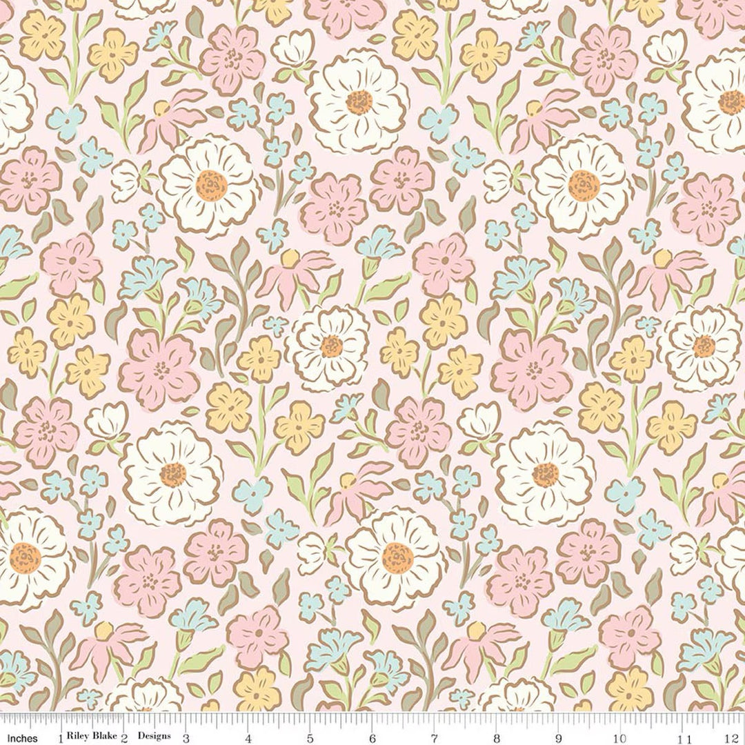 Pink fabric swatch of floral pattern with white, pink, yellow and blue flowers. There is a ruler at the bottom for scale.
