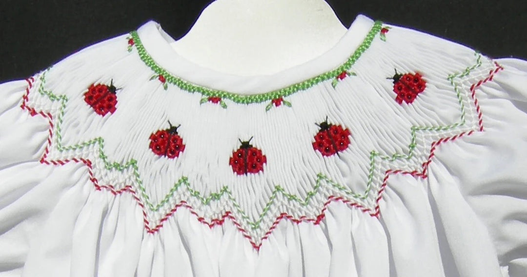 White garment with red ladybug embroidery on a black background