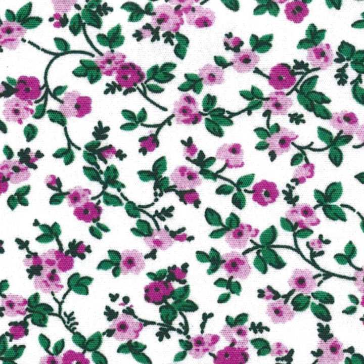 A dense all-over floral print featuring small pink flowers and green leaves on a white background.