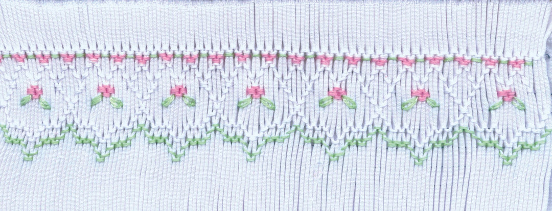 Smocking plate with a geometric design and small flowers on a bishop designed for preemies and newborns.