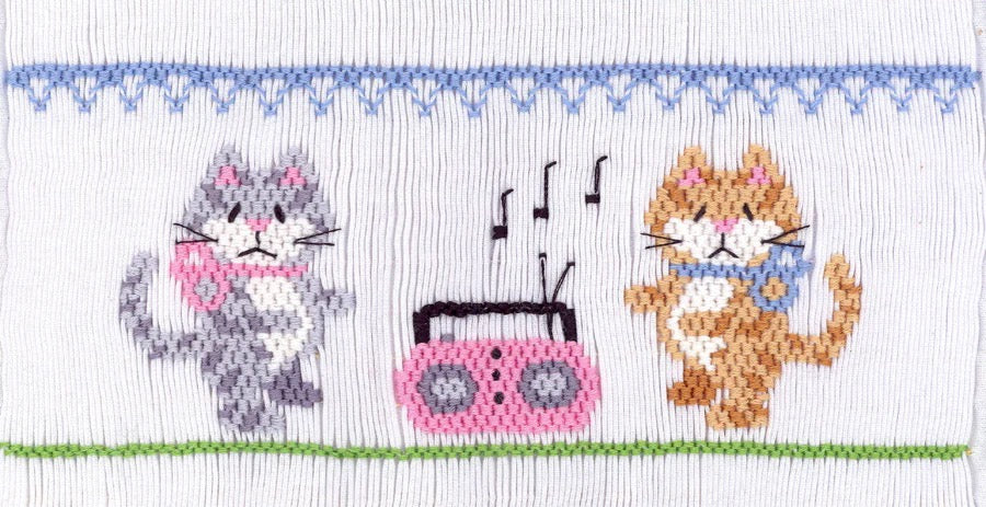 Smocking design of two cats with a radio and music notes.