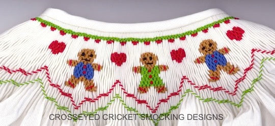 White fabric with smocked gingerbread men and hearts, featuring 'Crosseyed Cricket Smocking Designs'.