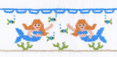 Smocking plate with two mermaids. 8 rows of smocking on a yoke.