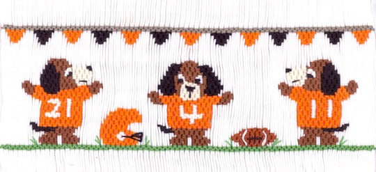 Smocking plate with hound dogs dressed for football and includes a helmet and jerseys. 7 1/2 rows of smocking on a yoke.