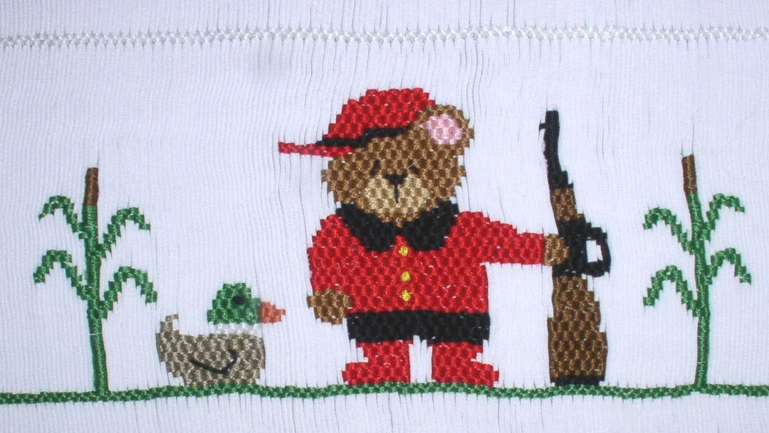 Smocking plate with a bear with a riffle gun and a duck. 10 rows of smocking on a yoke.
