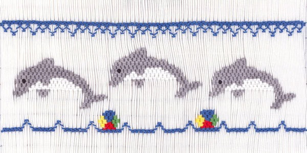 Smocking plate with three dolphins and beach balls. 8 rows of smocking on a yoke.