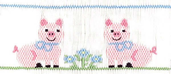 Two cute smiling piglets sitting around a flower bush.