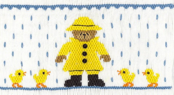 Smocking plate with a bear in a raincoat with two ducks on each side. 10 rows of smocking on a yoke.