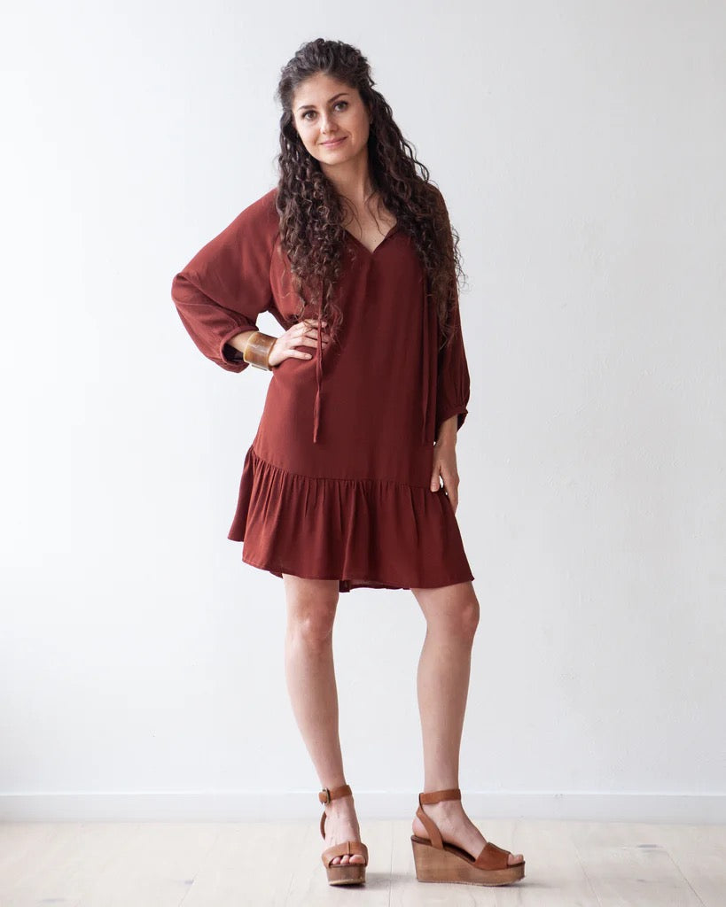 girl in brown dress and shoes against a white background