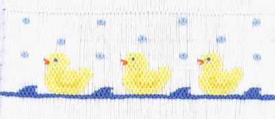 Smocking plate with three rubber duckies in water. 7 rows of smocking on a yoke.