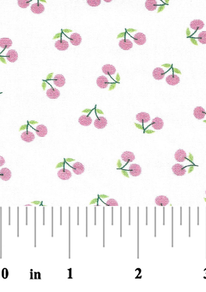 pink cherries with green leaves and stems on a white background with a ruler at the bottom for scale