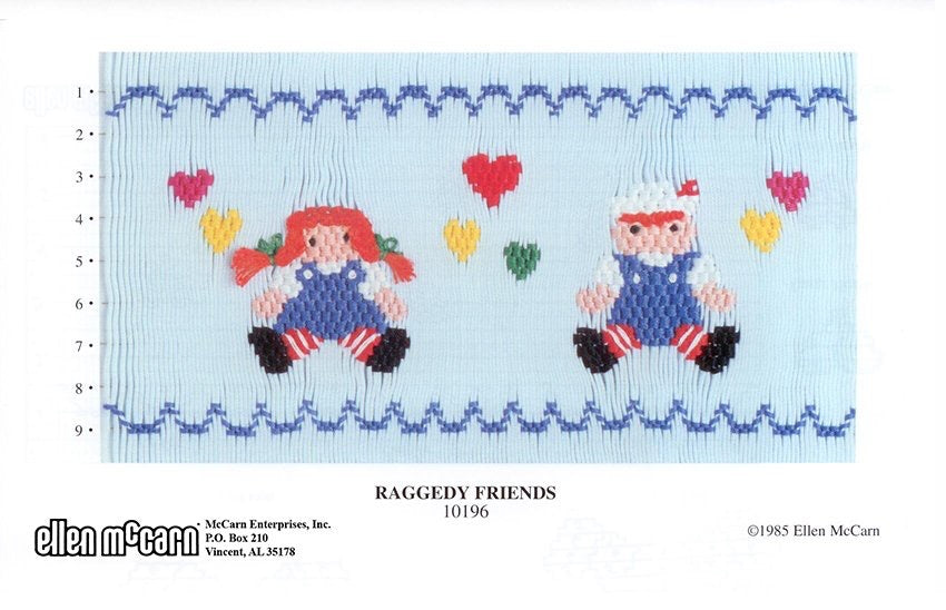 Smocking plate of Raggedy Ann and Andy on a blue background with hearts.
