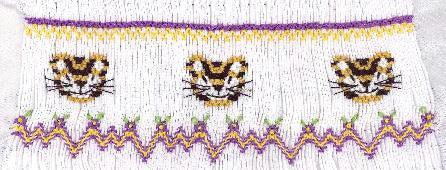 Smocking plate with three tiger faces and a geometric design. 7 1/4 rows of smocking on a bishop.
