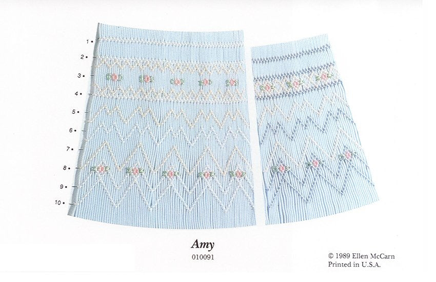 Smocking plate with a geometric designs. 9-10 rows of smocking on a bishop with blue white smocking on a blue background.