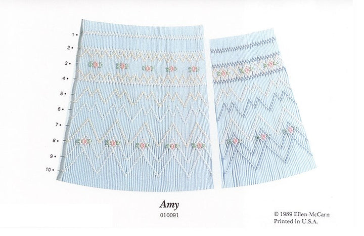 Smocking plate with a geometric designs. 9-10 rows of smocking on a bishop with blue white smocking on a blue background.