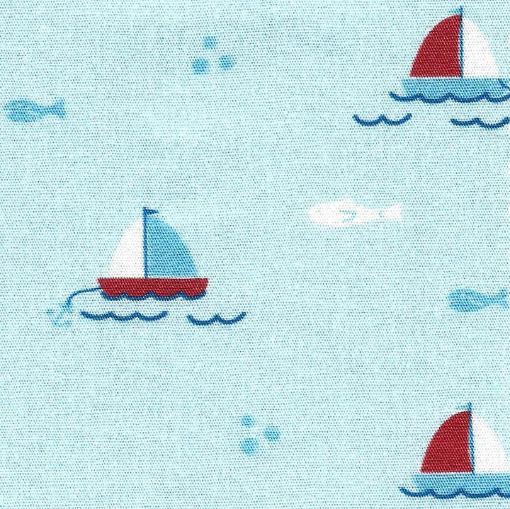 Fabric pattern with sailboats and fish on a light blue background