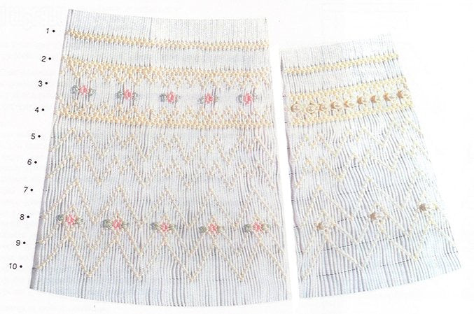 Smocking plate with a geometric designs. 9-10 rows of smocking on a bishop with ecru pink and green embroidery