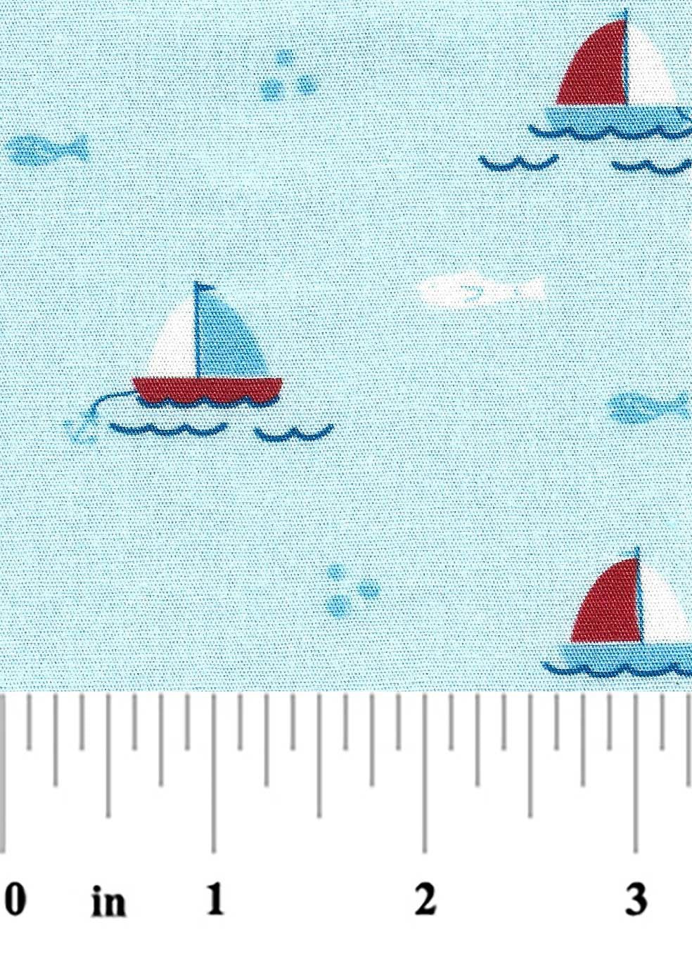 Fabric with sailboat pattern on a blue background, featuring a ruler at the bottom.