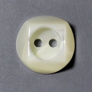 Round beige button with two holes on a gray background