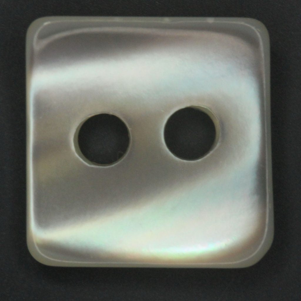 Square button with two holes on a dark background