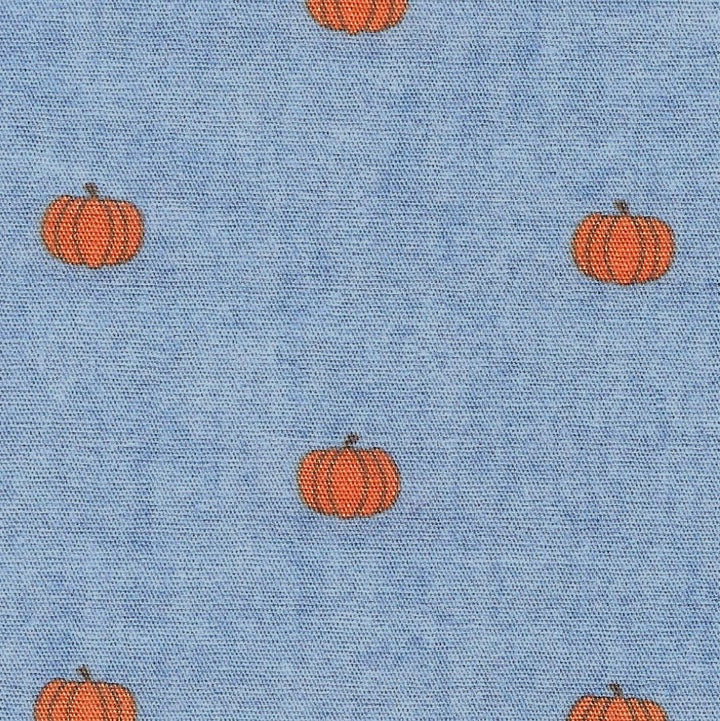 Pattern of orange pumpkins on a blue fabric background