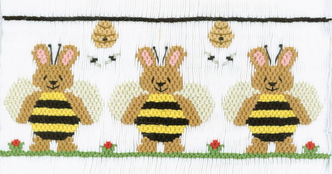 Smocking plate with three bunnies in bee costumes. 9 1/2 rows of smocking on a yoke.