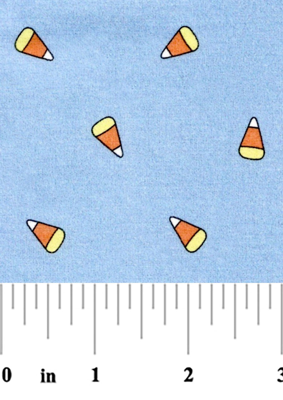 fabric swatch of candy corn on a blue background with a ruler at the bottom for scale