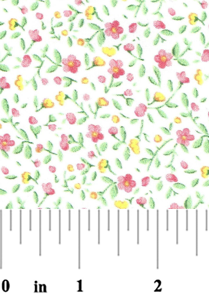 fabric swatch of a pink and green floral print on a solid white background with a ruler at the bottom for scale