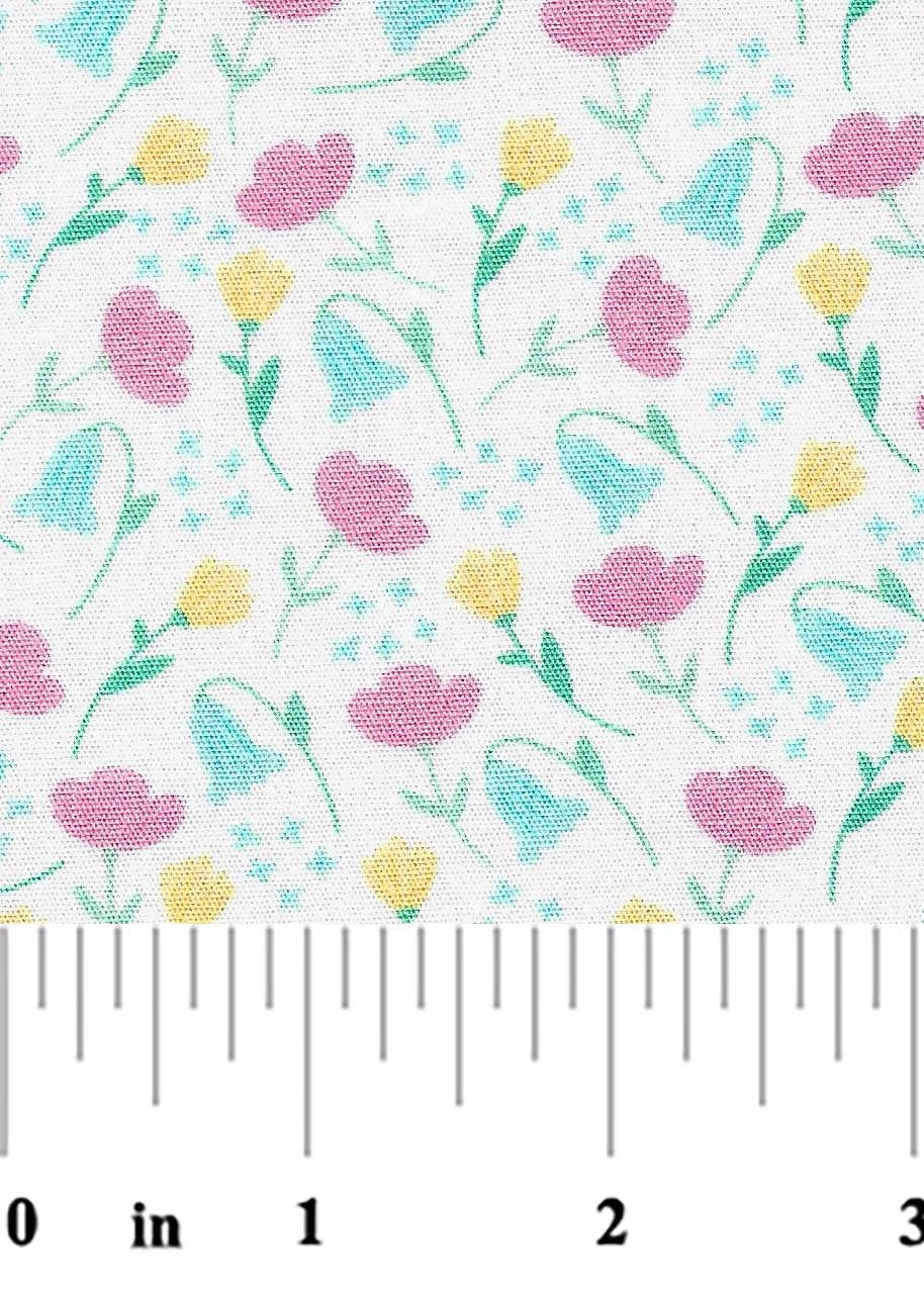 Floral pattern with pink, yellow, and blue flowers on a white background, measured against a ruler.