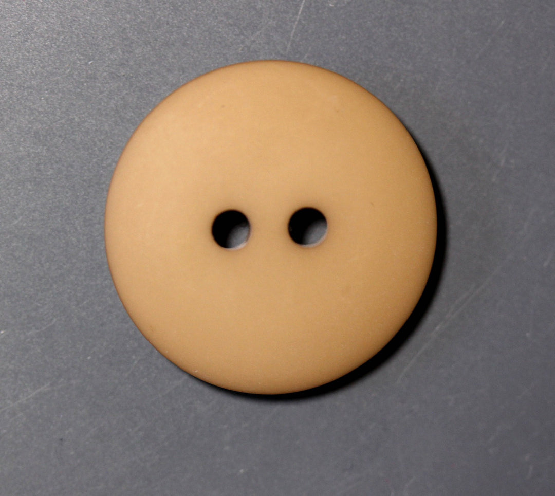 Brown button with two holes on a gray background