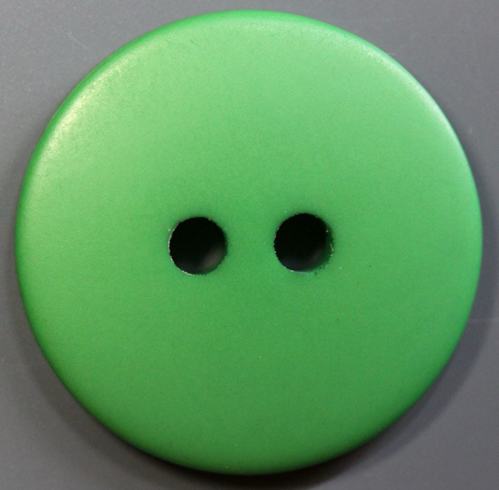 Green button with two holes on a gray background