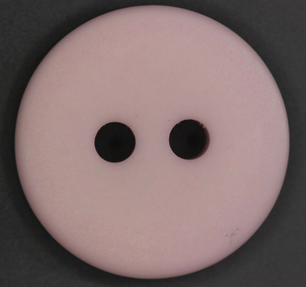 Round lilac button with two holes on a dark background