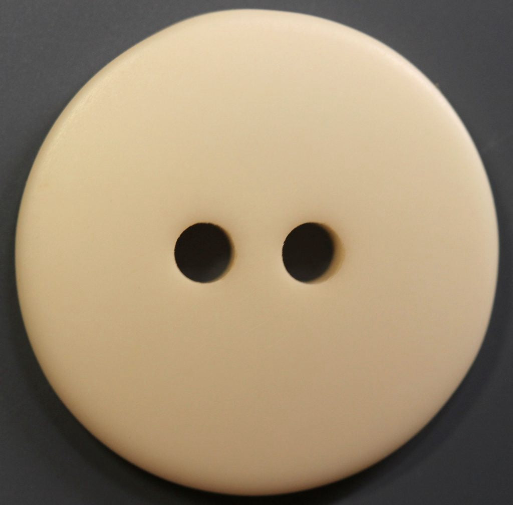 Beige button with two holes on a black background