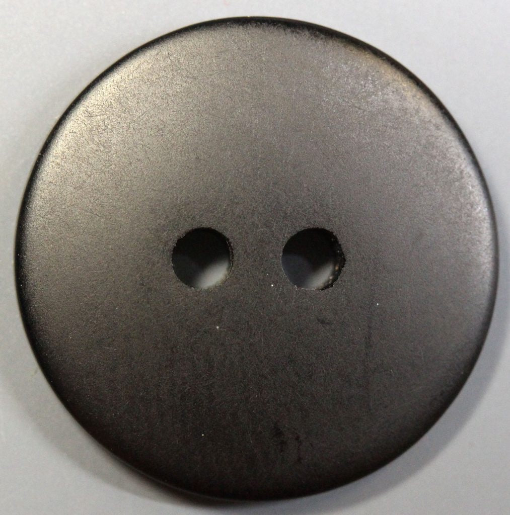 Black button with two holes on a white background