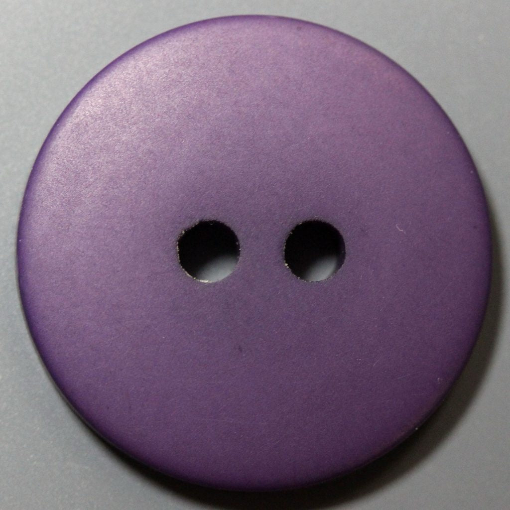 Purple button with two holes on a gray background
