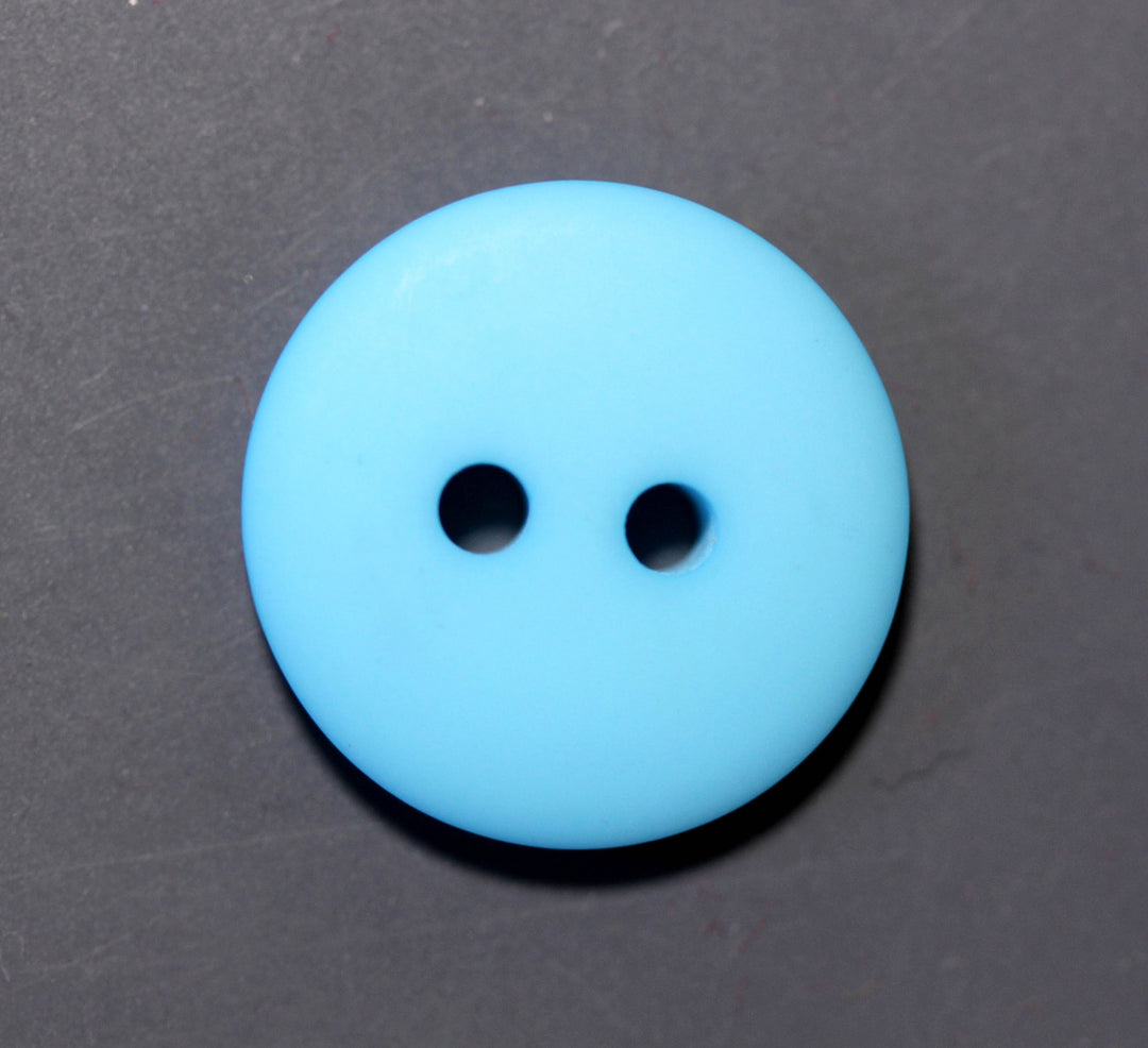 Blue button with two holes on a dark gray background