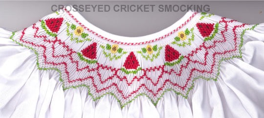 Embroidered neckline with red floral patterns on a white garment.