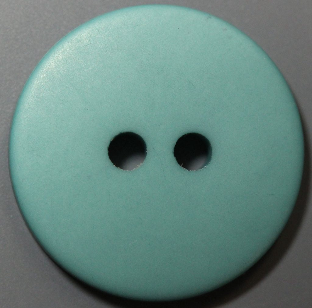 Teal button with two holes on a gray background