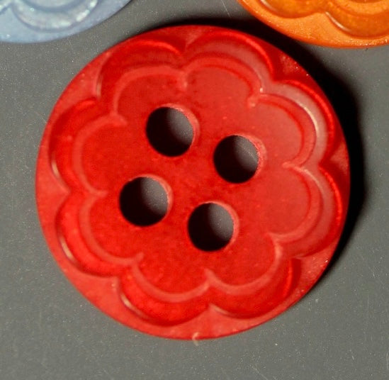 Red floral-patterned button on a gray background
