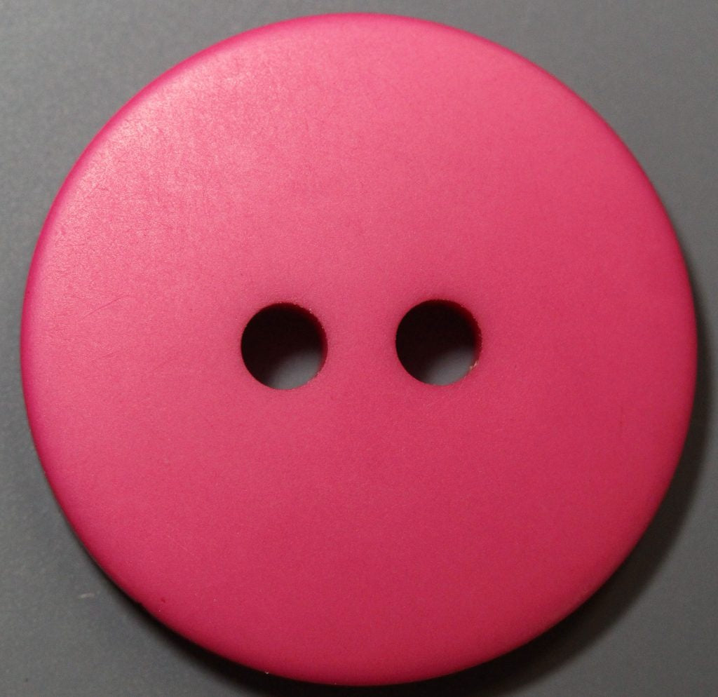 Close-up of a pink button on a gray background