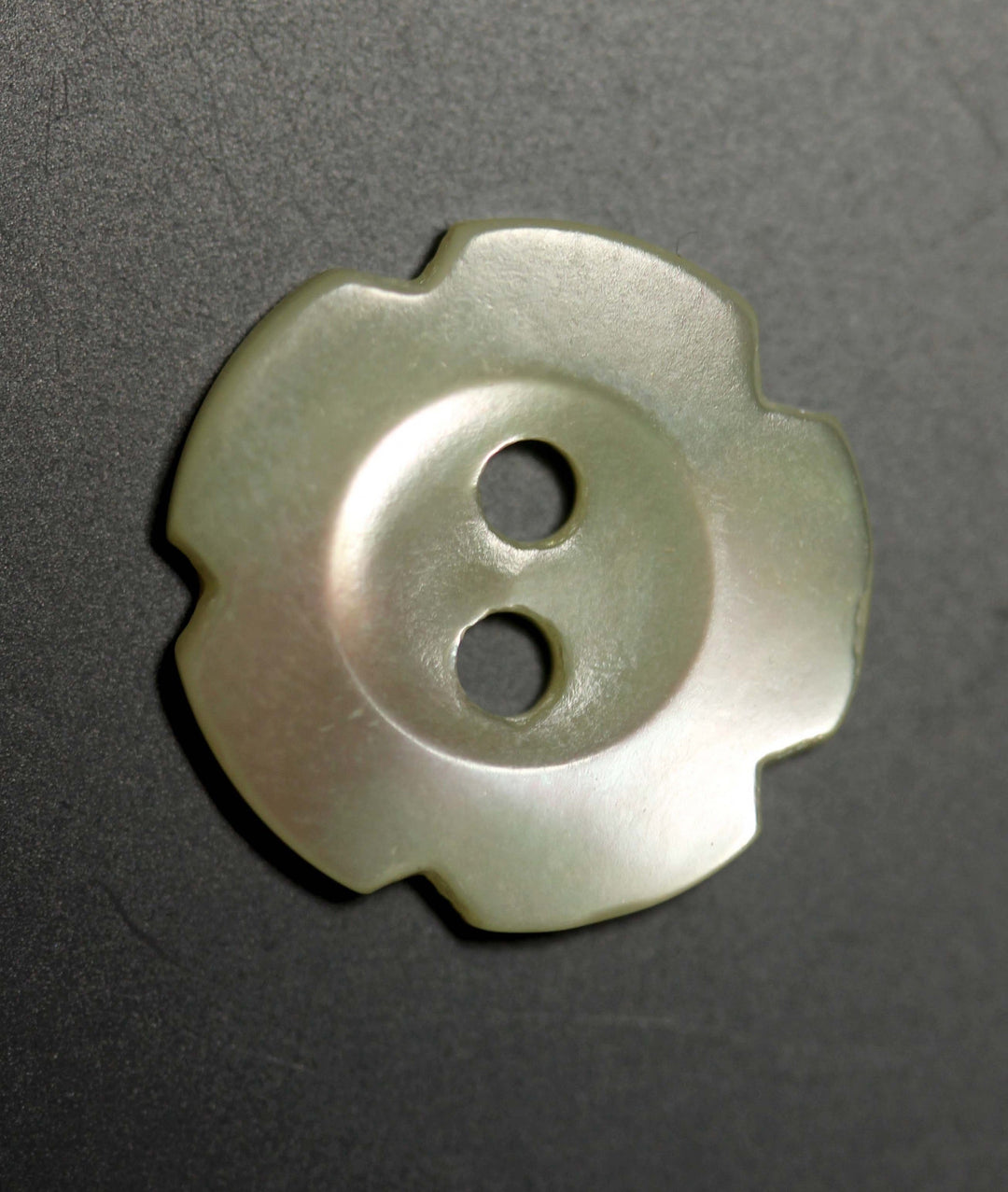 Floral-patterned button on a dark gray background
