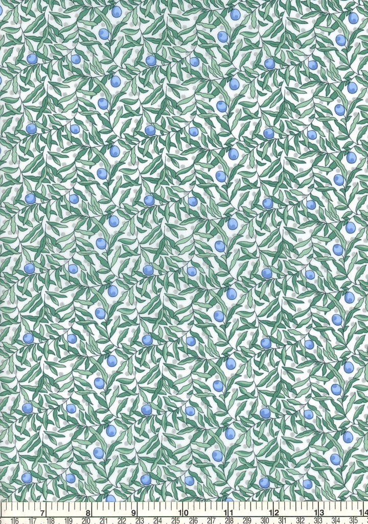 Fabric with green leaf pattern and blue berries on a white background, ruler at the bottom for scale.