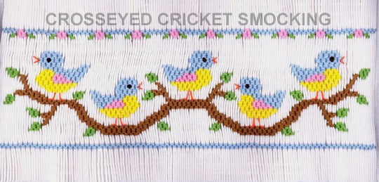 Smocked fabric with colorful birds on a branch design.