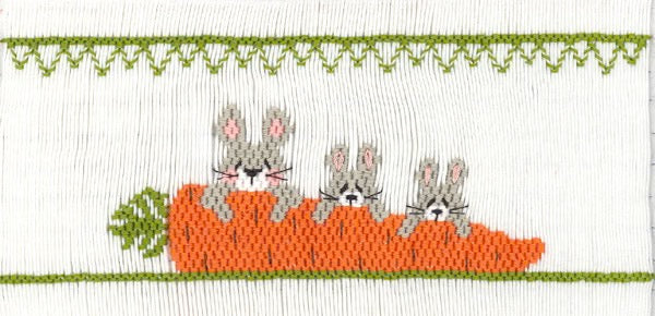 Smocking plate with three bunnies and a large carrot. 8 1/2 rows of smocking on a yoke.