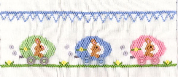 Smocking plate with three bunnies in cars with buttons for wheels. 7 rows of smocking on a yoke.