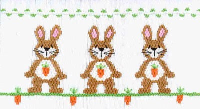 Smocking plate with three bunnies and carrots. 10 1/4 rows of smocking on a yoke.
