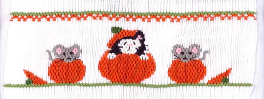 Smocking plate with a cat and two mice inside three pumpkins. 7 rows of smocking on a yoke.