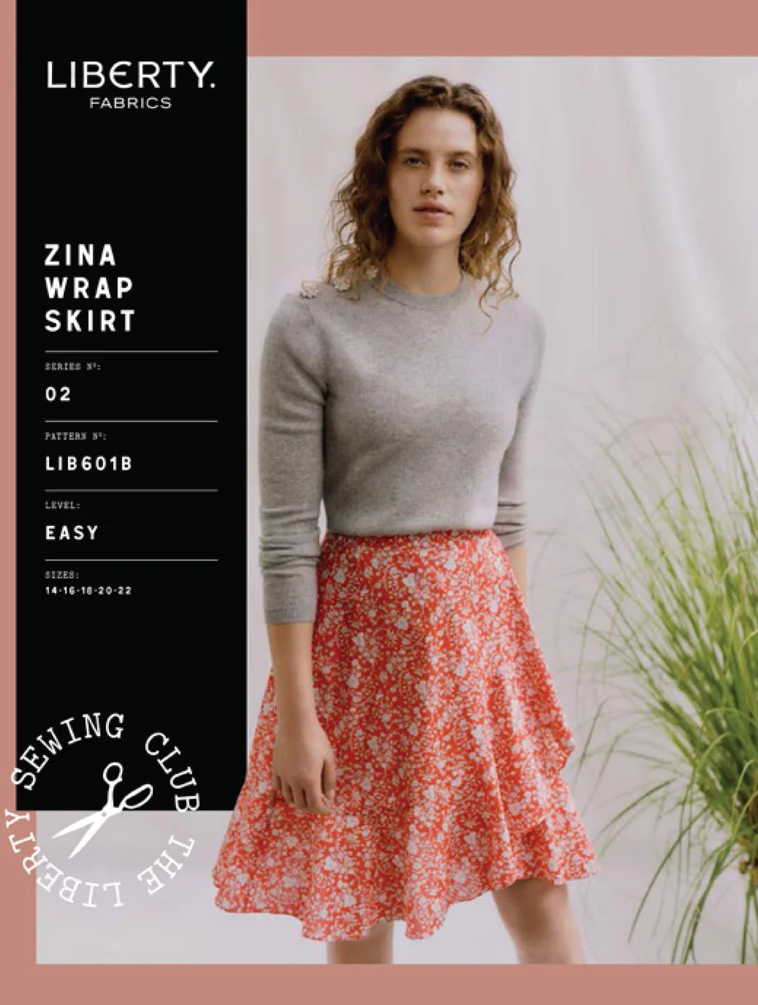 Woman wearing a red floral skirt and gray sweater with Liberty Fabrics branding.