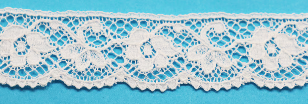 White floral lace trim with an intricate openwork pattern, shown horizontally against a solid bright blue background.