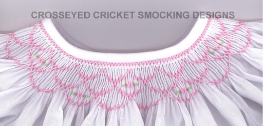 White garment with pink smocking designs on a light gray background